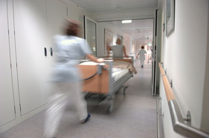 Nurses pushing hospital bed, gurney